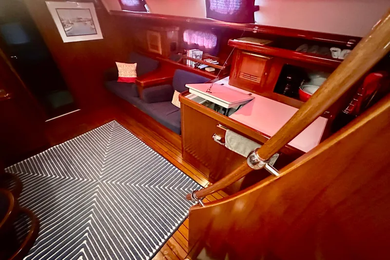 Slide: The Image of Interior of 2004 Beneteau 50 yacht with wooden finish and cozy seating area. - 9