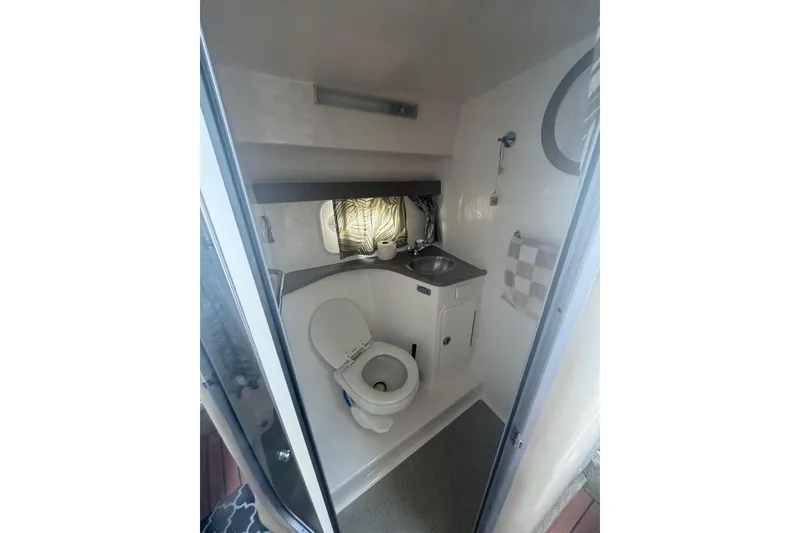 Slide: The Image of 2007 Rinker 320 Express Cruiser bathroom with toilet, sink, and towel rack. - 11
