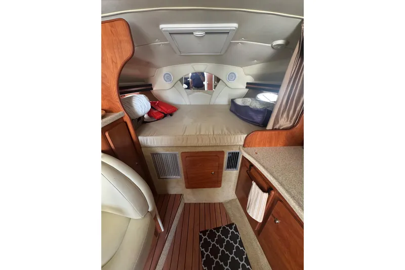 Slide: The Image of 2007 Rinker 320 Express Cruiser cabin interior with bed, wood cabinetry, and countertop. - 17