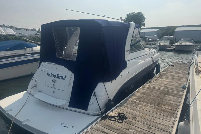Slide: The Image of 2007 Rinker 320 Express Cruiser docked with blue canopy, rear view. - 23