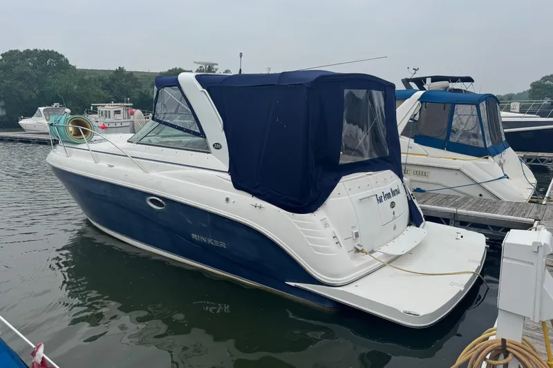 Slide: The Image of 2007 Rinker 320 Express Cruiser docked at a marina, featuring a blue and white exterior. - 5