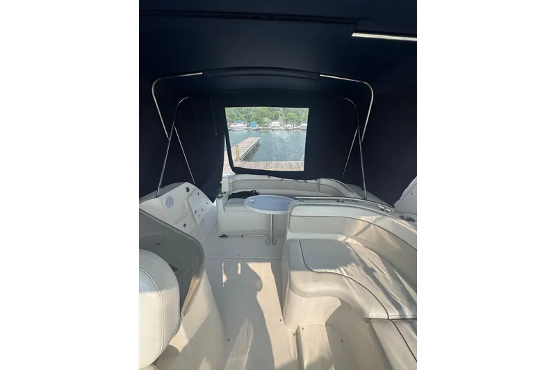 Slide: The Image of 2007 Rinker 320 Express Cruiser interior with seating and table, dock view. - 7