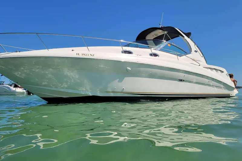 The Image of 2003 Sea Ray 320 Sundancer boat on clear water under blue sky. - 0