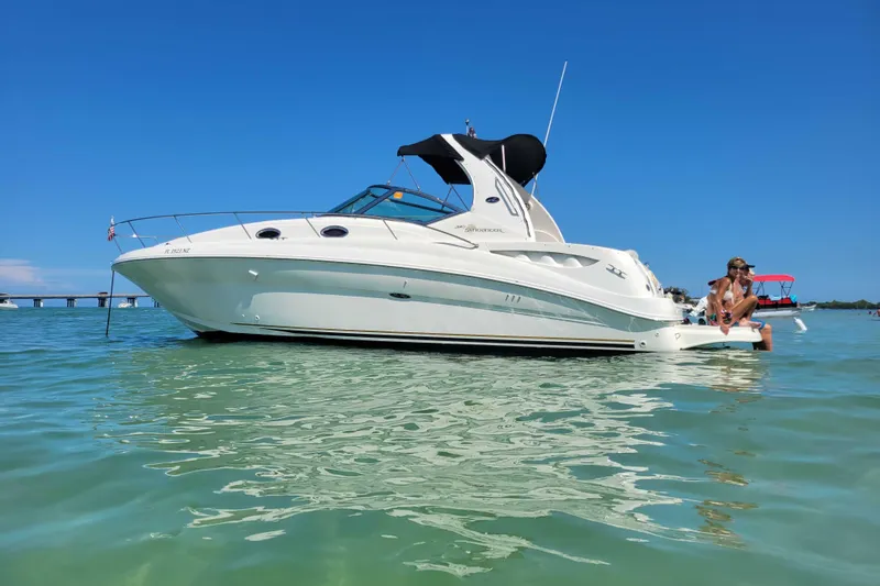 Slide: The Image of 2003 Sea Ray 320 Sundancer boat on clear water with people relaxing onboard. - 1