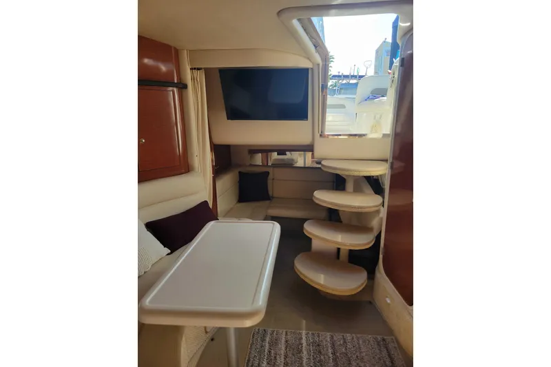 Slide: The Image of Interior of 2003 Sea Ray 320 Sundancer yacht with seating, table, and stairs. - 18