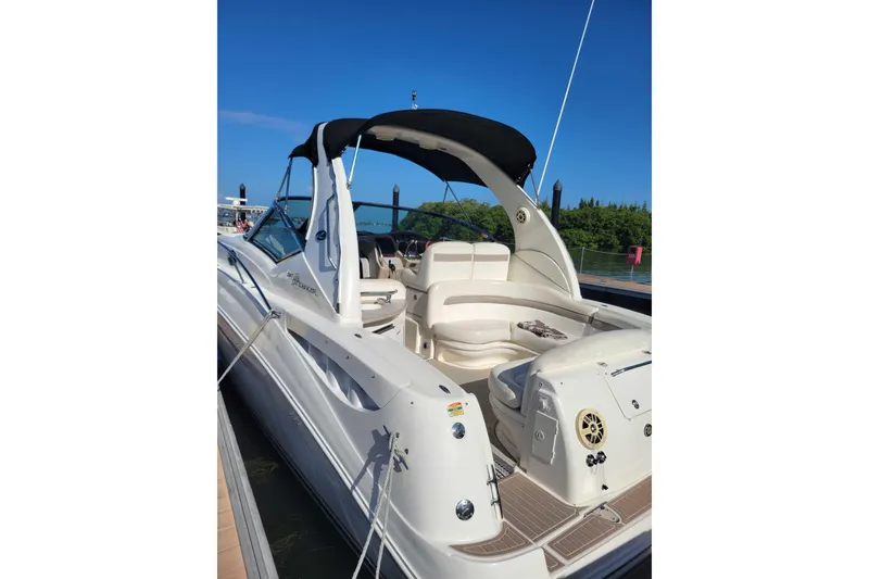 Slide: The Image of 2003 Sea Ray 320 Sundancer boat docked, featuring spacious seating and sleek design. - 6