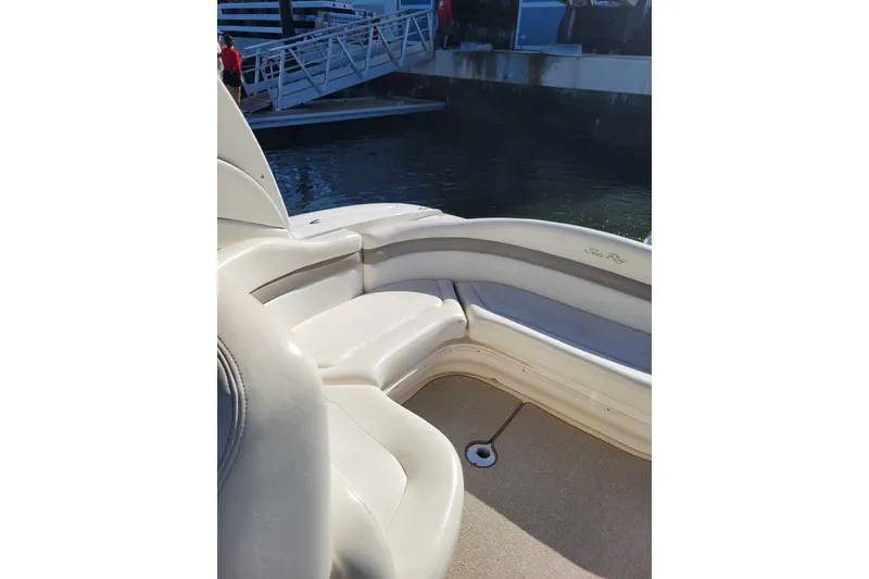 Slide: The Image of 2003 Sea Ray 320 Sundancer boat interior with white seating near dock. - 7