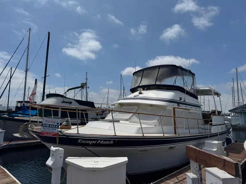 The Image of 1984 Spindrift 39 ft. Aft Cabin Twin Diesel yacht docked, "Escape Hatch" visible, for sale sign. - 0