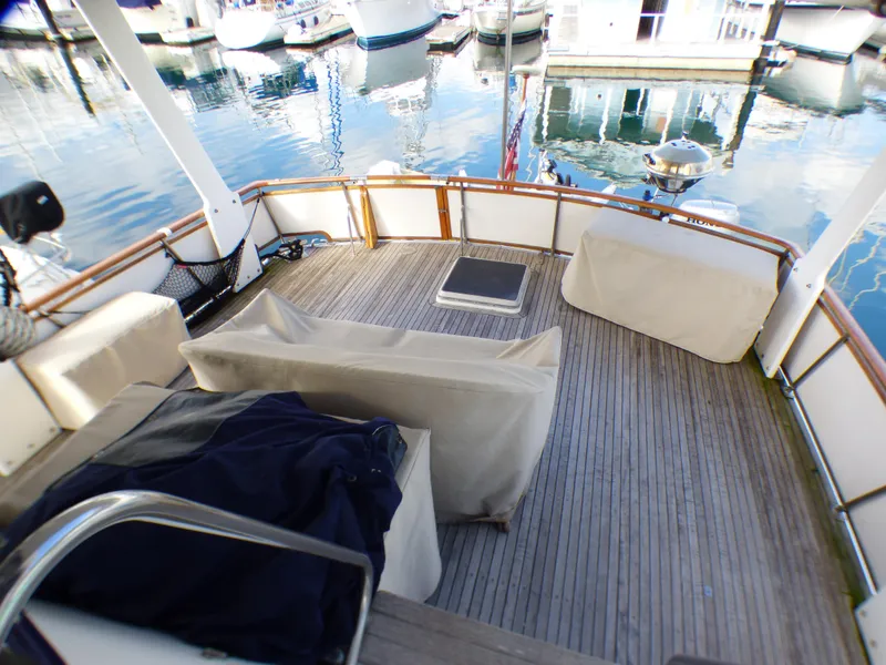 Slide: The Image of 1984 Spindrift 39 ft. aft cabin deck with covered seating and marina view. - 11
