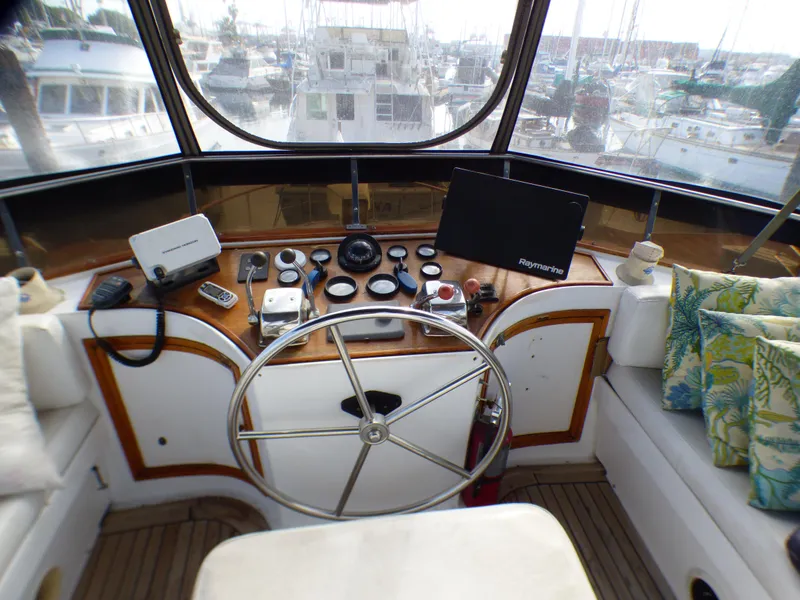 Slide: The Image of 1984 Spindrift 39 ft. Aft Cabin helm with steering wheel, navigation instruments, and marina view. - 16