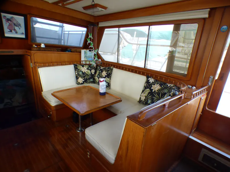 Slide: The Image of 1984 Spindrift 39 ft. aft cabin interior with wooden dining area and cushioned seating. - 33