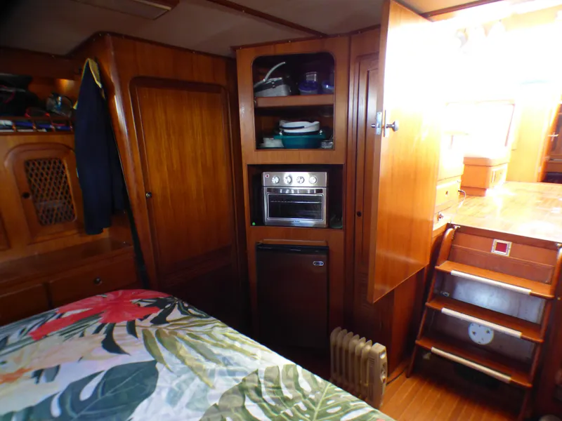 Slide: The Image of 1984 Spindrift 39 ft. aft cabin interior with wood paneling and floral bedding. - 48