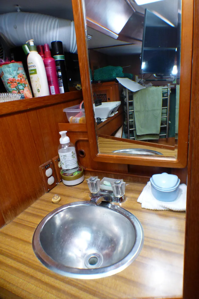 Slide: The Image of 1984 Spindrift 39 ft. Aft Cabin bathroom with sink, mirror, and toiletries. - 49