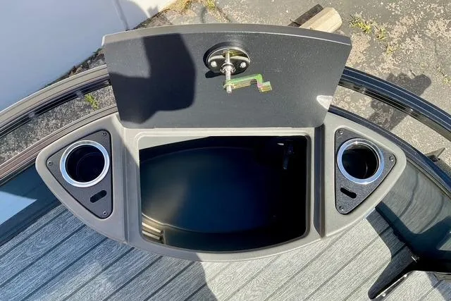 Slide: The Image of 2026 Ranger Reata 220F boat storage compartment with cup holders and key lock. - 11
