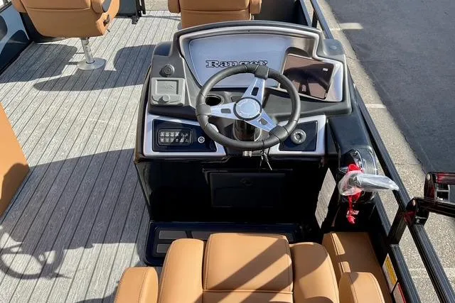 Slide: The Image of 2026 Ranger Reata 220F boat interior with steering wheel and tan seating. - 14