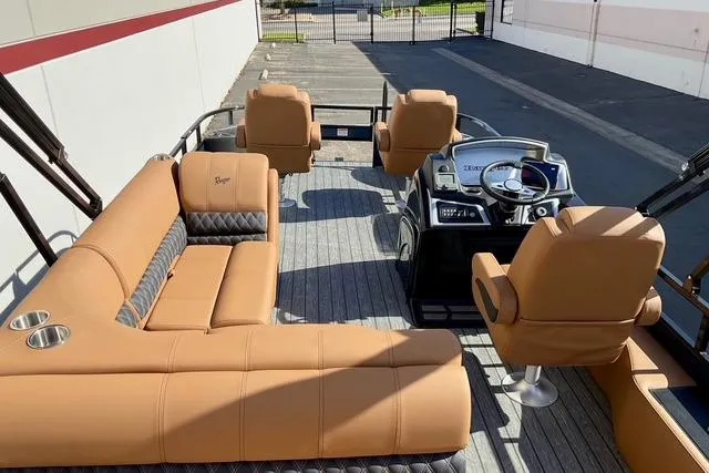 Slide: The Image of 2026 Ranger Reata 220F boat interior with tan seating and modern steering console. - 15