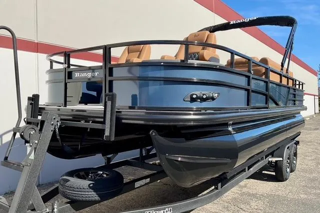 Slide: The Image of 2026 Ranger Reata 220F pontoon boat on trailer, sleek design, outdoor setting. - 2