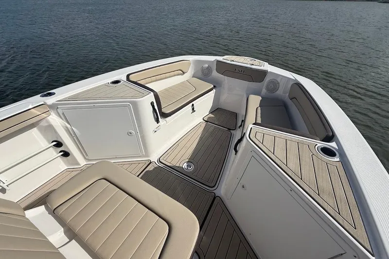 Slide: The Image of 2022 Yamaha Boats 210 FSH Sport interior with cushioned seating and storage compartments. - 10