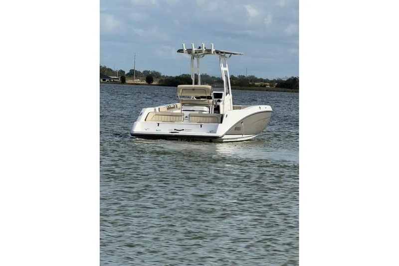 Slide: The Image of 2022 Yamaha Boats 210 FSH Sport on calm water, rear view. - 4
