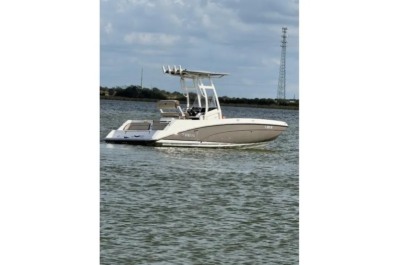 Slide: The Image of 2022 Yamaha Boats 210 FSH Sport on calm water under cloudy sky. - 5
