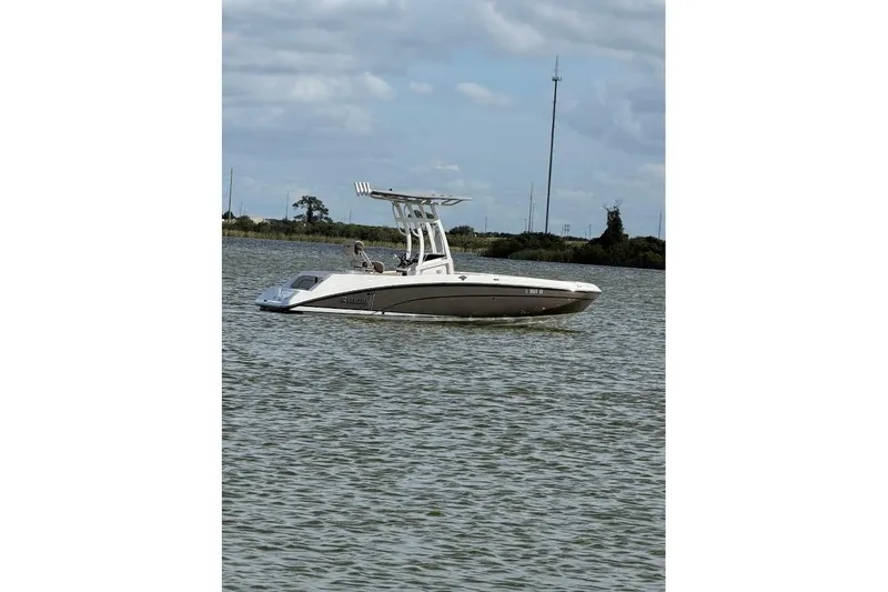 Slide: The Image of 2022 Yamaha Boats 210 FSH Sport on calm water under cloudy sky. - 6