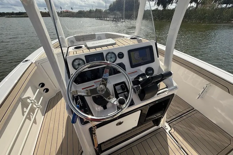 Slide: The Image of 2022 Yamaha Boats 210 FSH Sport dashboard with steering wheel and navigation system. - 7