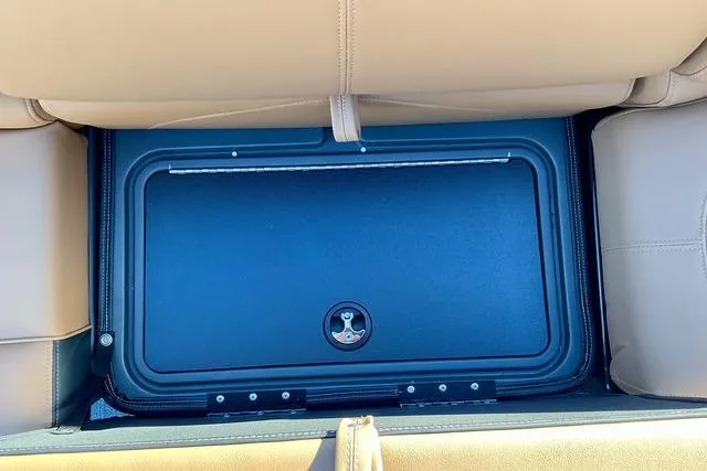 Slide: The Image of Under-seat storage compartment in 2026 Regency 250DL boat, featuring secure latch and beige upholstery. - 18