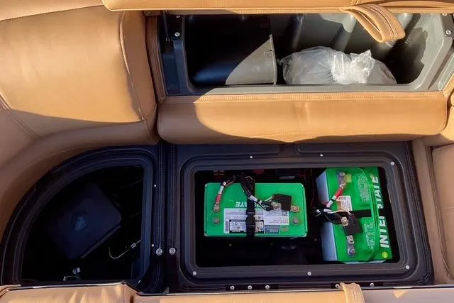 Slide: The Image of Interior view of a 2026 Regency 250DL showing battery compartment under tan seats. - 26