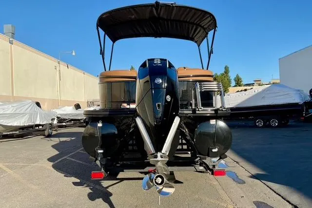 Slide: The Image of 2026 Regency 250DL pontoon boat with canopy and powerful outboard motor in a marina. - 3