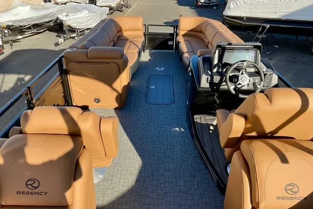 Slide: The Image of 2026 Regency 250DL pontoon boat with luxurious tan seating and modern dashboard. - 9