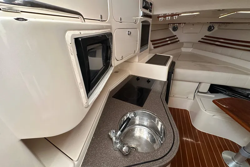 Slide: The Image of 2004 Grady-White Express 330 interior with kitchenette, sink, and seating area. - 18