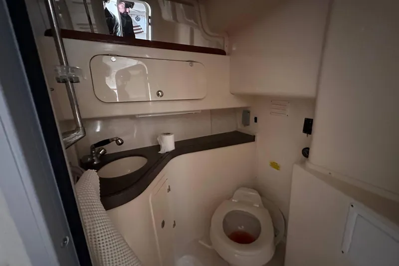 Slide: The Image of 2004 Grady-White Express 330 boat bathroom with sink, toilet, and storage cabinets. - 19