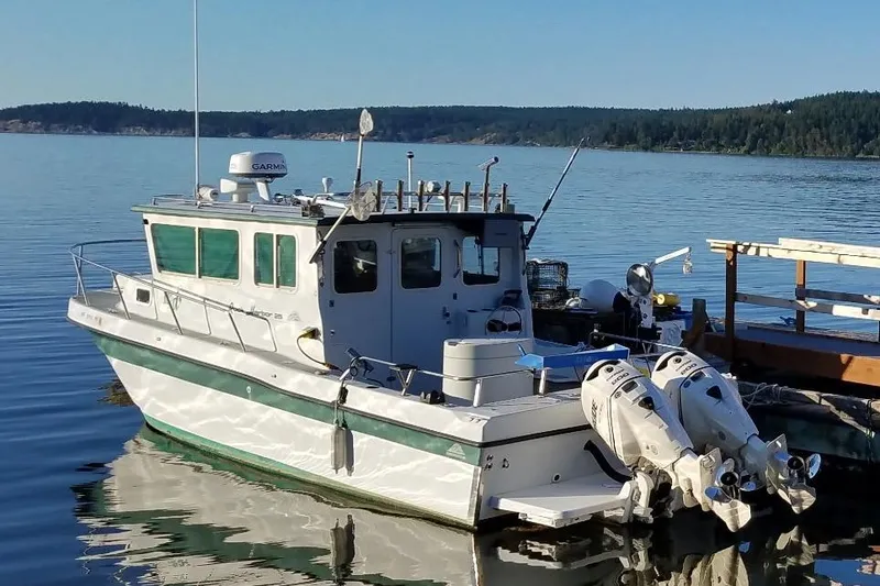 The Image of 1998 Davis Rock Harbor 25 boat docked on calm water with twin outboard motors. - 0