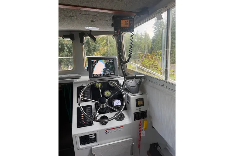 Slide: The Image of 1998 Davis Rock Harbor 25 boat cockpit with steering wheel and navigation equipment. - 10