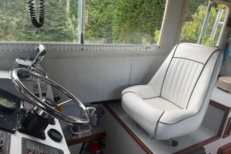 Slide: The Image of Interior of 1998 Davis Rock Harbor 25 boat with steering wheel and white captain's chair. - 11