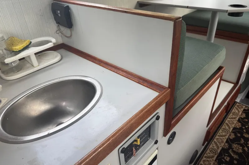Slide: The Image of Interior of 1998 Davis Rock Harbor 25 boat with sink and seating area. - 18