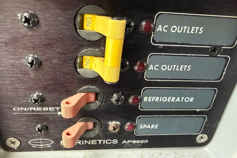 Slide: The Image of Electrical panel with switches for AC outlets, refrigerator, and spare on a 1998 Davis Rock Harbor 25. - 20