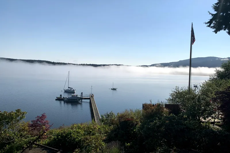 Slide: The Image of A serene harbor view with boats, mist, and a Davis Rock Harbor 25 from 1998. - 4