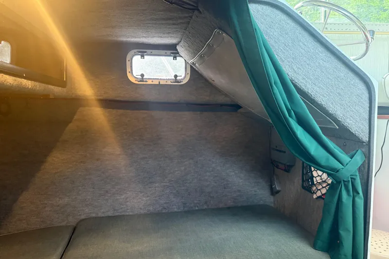 Slide: The Image of Cozy cabin interior of 1998 Davis Rock Harbor 25 boat with green curtains and window. - 8