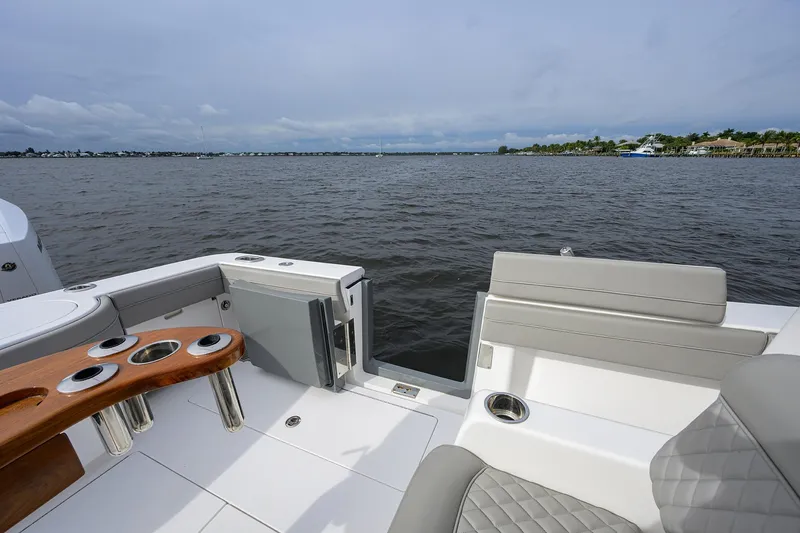 Slide: The Image of 2024 Valhalla Boatworks V-41 interior with seating and rod holders, overlooking calm waters. - 24
