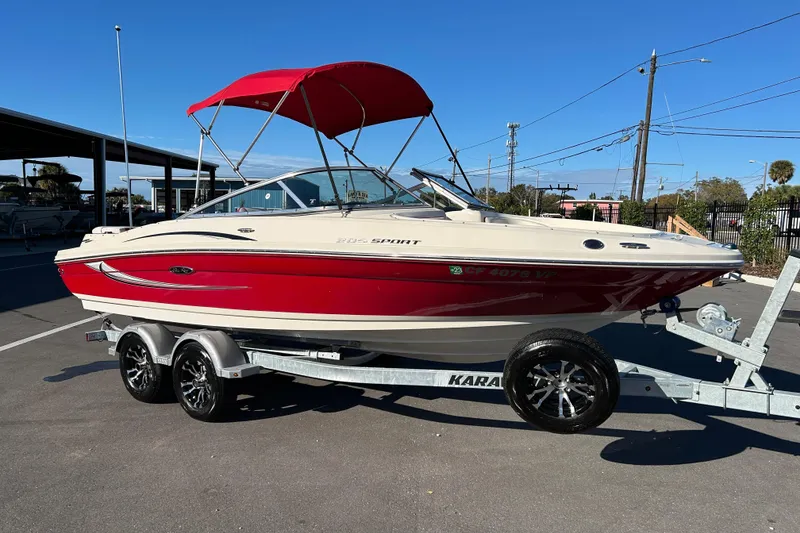The Image of 2010 Sea Ray 205 Sport boat with red canopy on a trailer. - 1