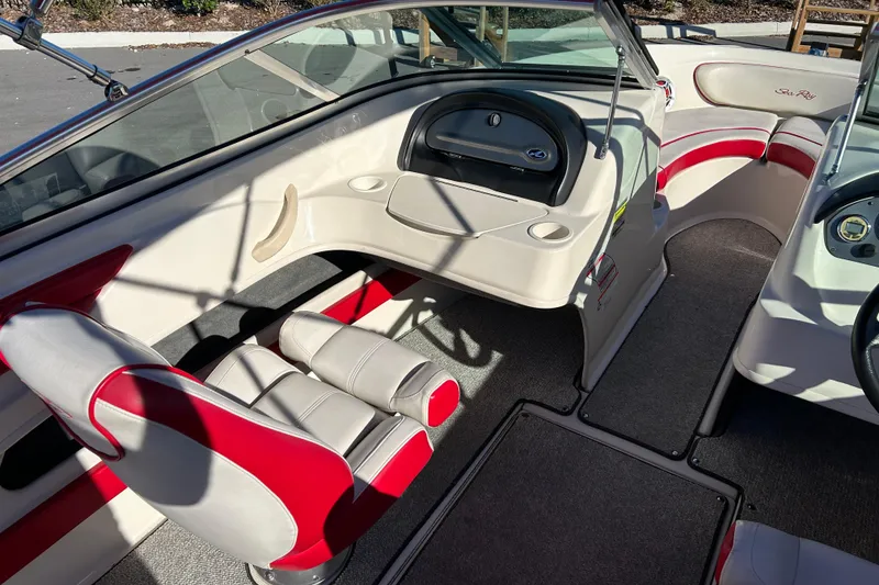 Slide: The Image of 2010 Sea Ray 205 Sport boat interior with red and white seating and dashboard. - 13