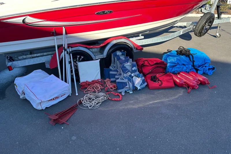 Slide: The Image of 2010 Sea Ray 205 Sport boat with accessories, including ropes and bags, on a trailer. - 18