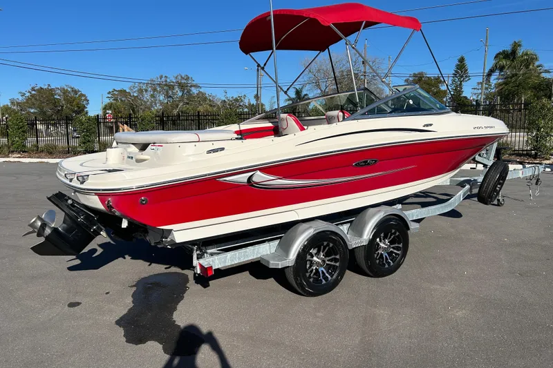 Slide: The Image of 2010 Sea Ray 205 Sport boat with red and white design on a trailer. - 2