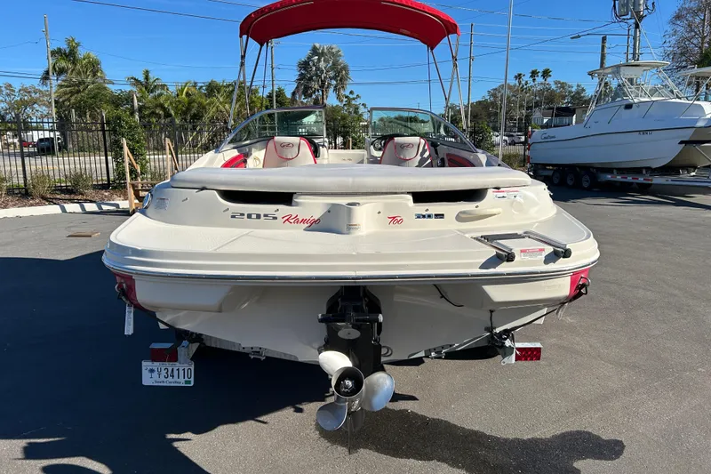 Slide: The Image of 2010 Sea Ray 205 Sport boat with red canopy, parked outdoors. - 3