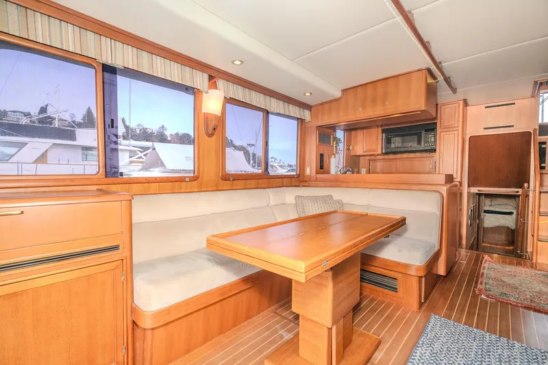 Slide: The Image of Luxurious 2001 Fleming 55 Pilothouse yacht interior with elegant wood finishes and spacious seating. - 12