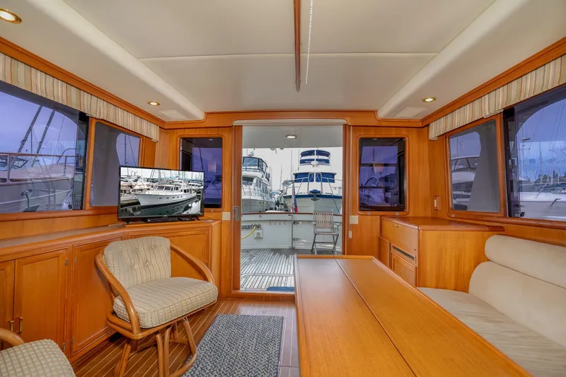 Slide: The Image of Interior of 2001 Fleming 55 Pilothouse yacht with wooden furnishings and marina view. - 15