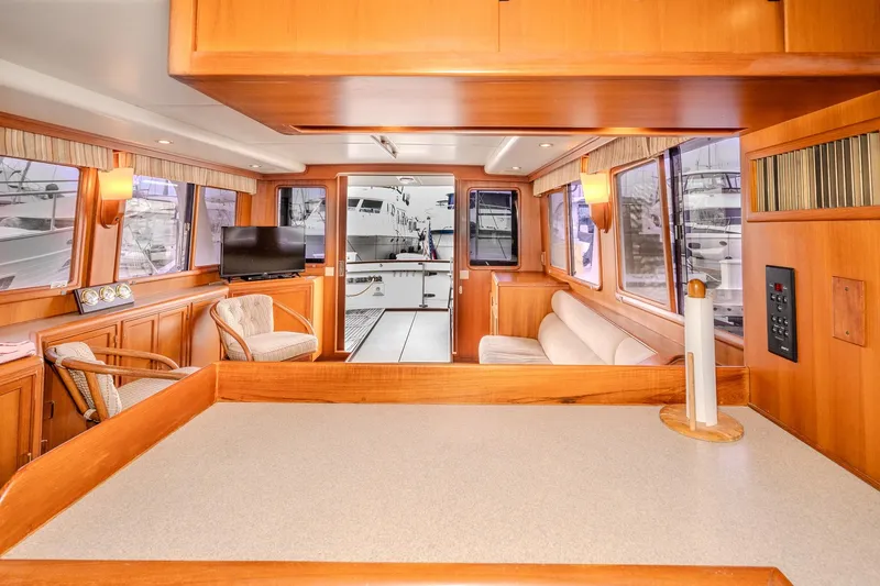 Slide: The Image of Interior of 2001 Fleming 55 Pilothouse yacht with wood finishes and seating area. - 22