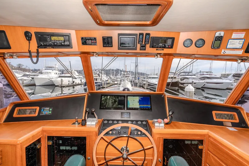Slide: The Image of Pilothouse interior of 2001 Fleming 55 yacht, showcasing navigation equipment and marina view. - 26