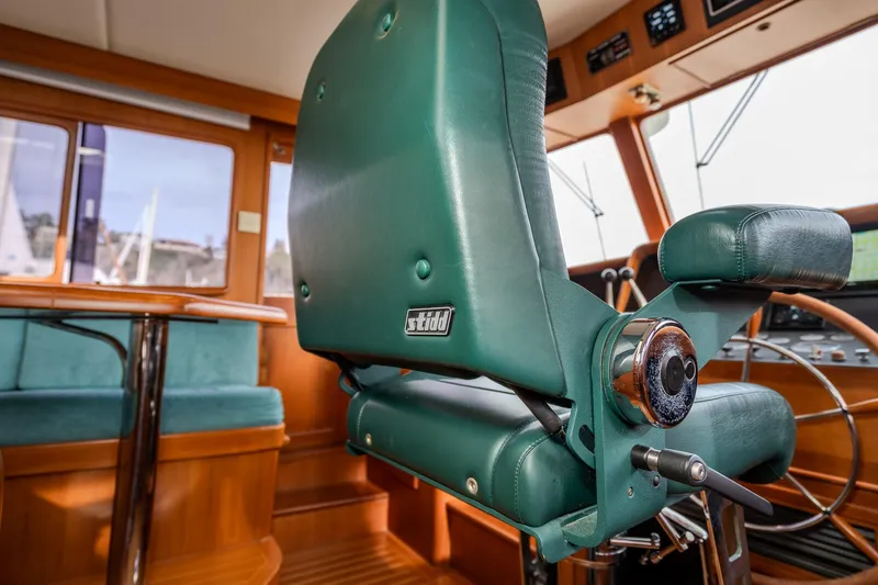 Slide: The Image of Pilothouse interior of 2001 Fleming 55 yacht with green captain's chair and wooden accents. - 33